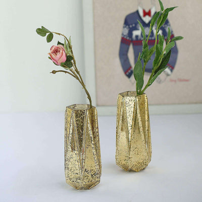 Gold textured vases with flowers on a plain backdrop.