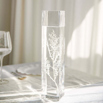 Elegant glass vase with etched botanical design filled with water.