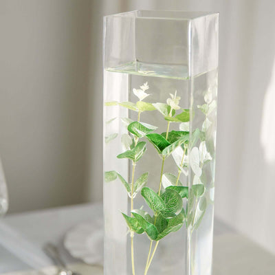 Clear glass vase with greenery and water, perfect for modern decor.