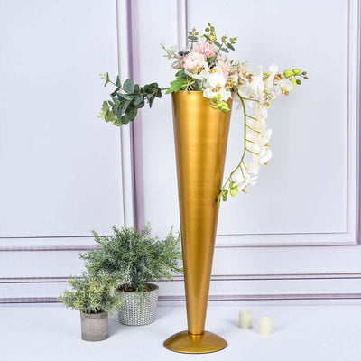 Gold cone vase with flowers and greenery, elegant home decor accent.