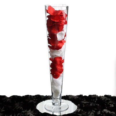 Tall glass vase filled with red and white rose petals