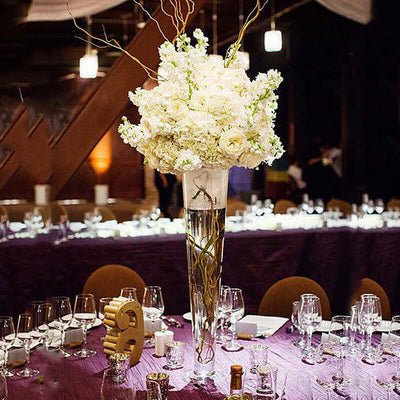 Elegant floral centerpiece in tall vase for event decor.