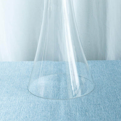 Clear glass vase on a blue textured surface.