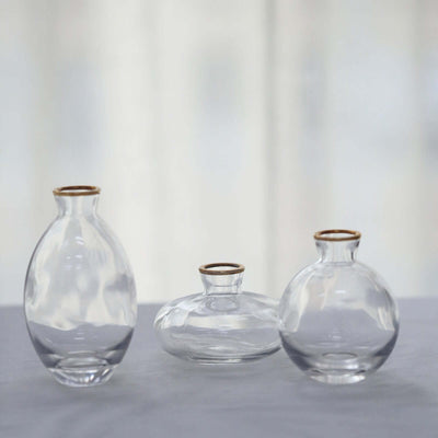 Clear glass vases with gold rims in varying shapes and sizes.