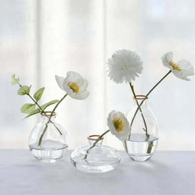 Clear glass vases with flowers arranged elegantly on a table