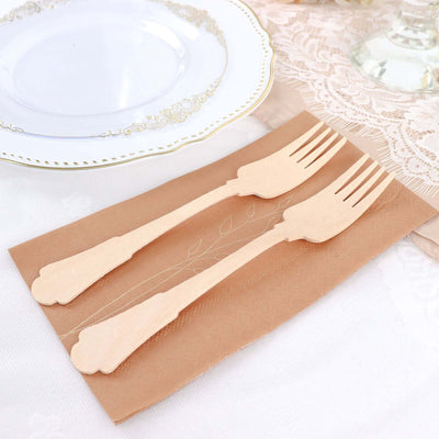 Wooden disposable forks on a decorative napkin for elegant dining.