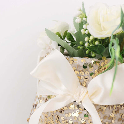 Gold sequin vase with white flowers and a satin bow.