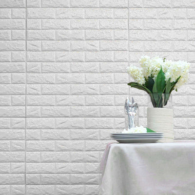 Decorative white brick wall with a table set for dining and a bouquet of flowers.