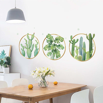 Cactus wall art in circular frames above a dining table with flowers and fruit.