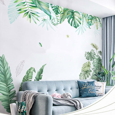 Living room with tropical leaf wall mural and cozy gray sofa.