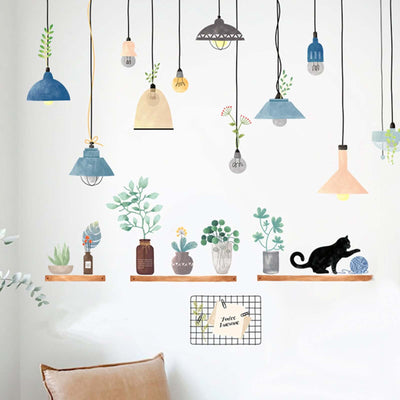 Colorful decorative wall lights and plants with a cat on a shelf.