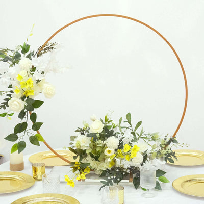 Floral centerpiece arrangement with a circular hoop backdrop on a dining table.