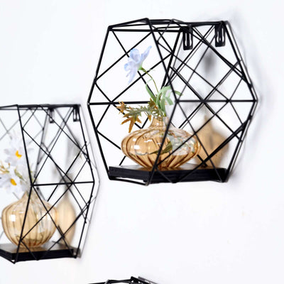 Geometric wall shelf with glass vase and flowers, black metal design.