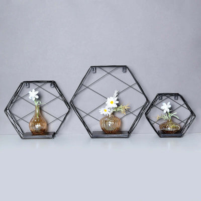 Geometric black metal wall shelves with vases and flowers.
