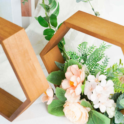 Wooden hexagon frames with flowers and greenery arrangement.