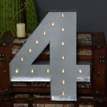 A silver metal number four with lights on it sits on a trunk
