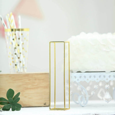 Gold geometric vase on a decorative table with cake and straws.