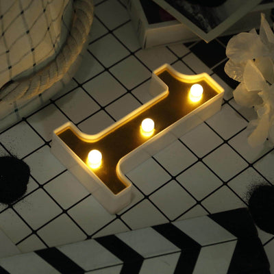 Illuminated decorative letter "H" with three candles on a patterned background.