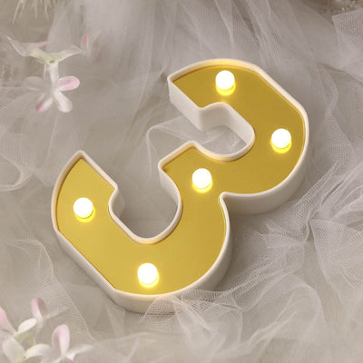 Yellow marquee number 3 decorative light on soft white fabric backdrop.