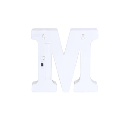 White decorative letter "M" on a plain backdrop.