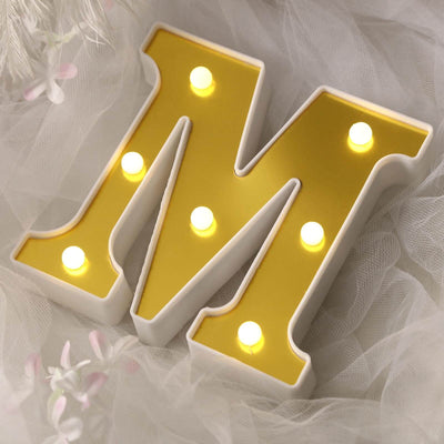 Light-up decorative letter "M" in yellow and white.