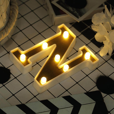 Illuminated letter Z marquee light on a patterned surface.