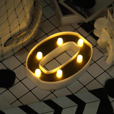 Decorative light-up letter "O" with warm white LED lights in a stylish setting.