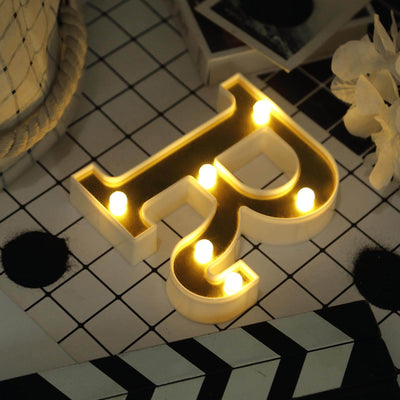 Decorative light-up letter "p" on a patterned surface.