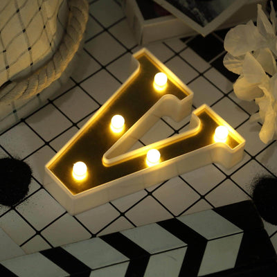 Illuminated decorative letter 'V' with lights on stylish tabletop