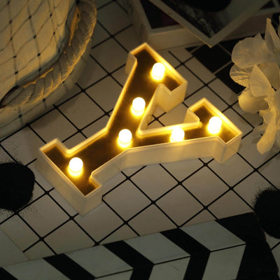 Illuminated letter "Y" marquee lamp on a patterned surface.