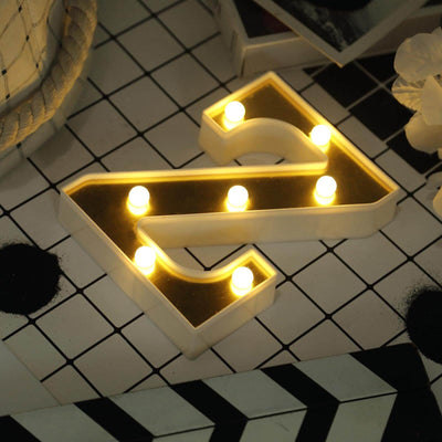 Decorative LED light letter A on a patterned tabletop.