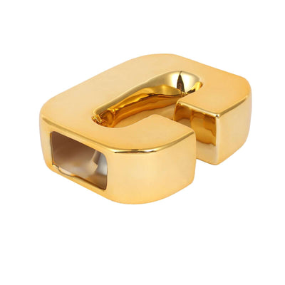 Gold letter "C" sculpture in a studio isolation shot.