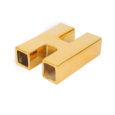 Gold letter H decor piece on a plain white background