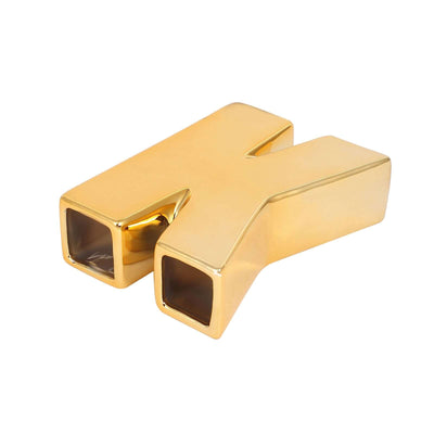 Gold letter "K" decorative piece on white background