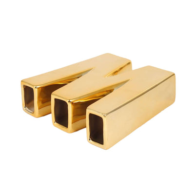 Gold letter "M" decor pieces in studio-style isolation.