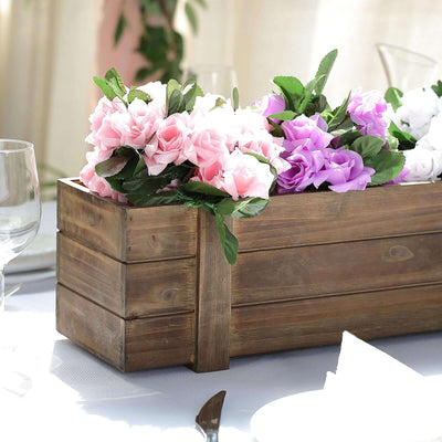 Wooden flower box with pink and purple artificial roses.