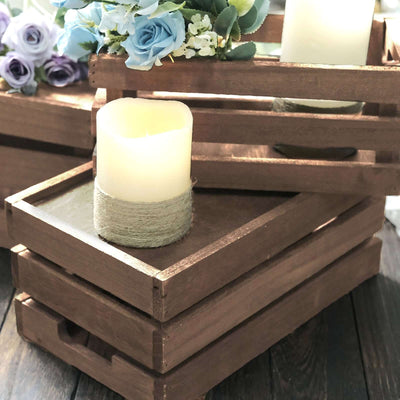 Wooden crates with candle and flowers in a rustic arrangement.