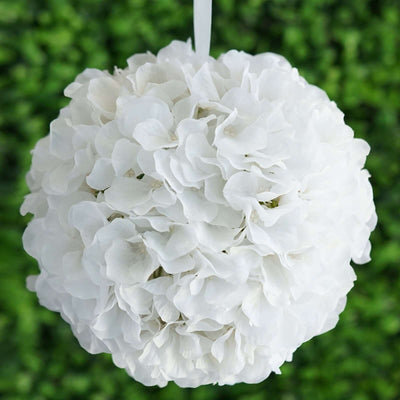 White floral pomander ball hanging against a green backdrop.