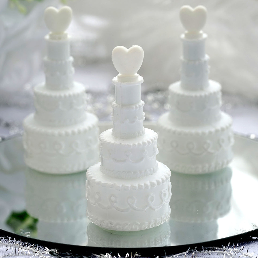 Miniature white wedding cake decorations with heart toppers. #whtbkgd