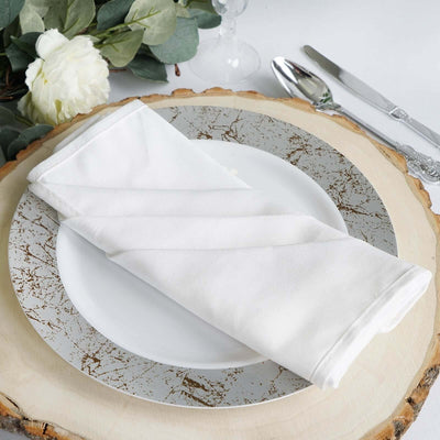 White napkin elegantly folded on a decorative plate with rustic wooden charger.