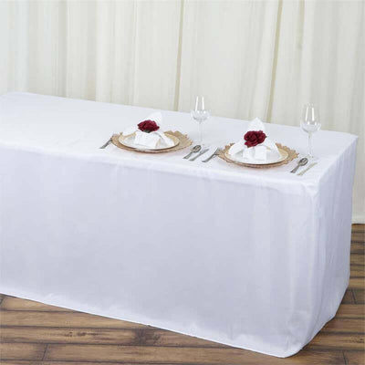 Elegant table setting with white tablecloth and decorative plates.