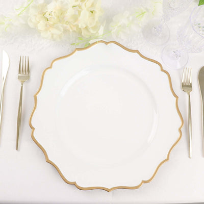 Elegant white plate with gold scalloped rim on a table setting.
