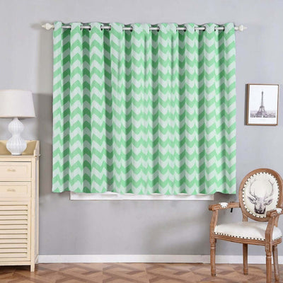 Chevron patterned curtains in mint green hanging in a cozy room setting.