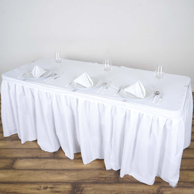 White tablecloth draped on a table set for dining with plates and glasses.