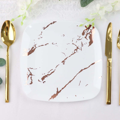 White square plate with rose gold marble design, styled with gold cutlery.