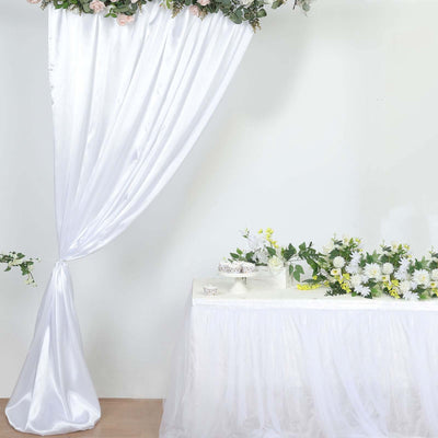 Elegant white drapery and floral arrangement for event decor setup.