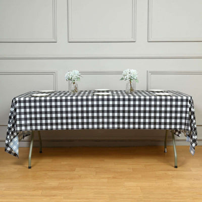 Black and white checkered tablecloth draped over a table with flower vases.