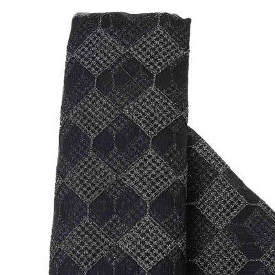 Black and gray patterned fabric roll with geometric design.