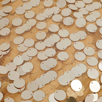 Gold circular sequins arranged on a textured surface.