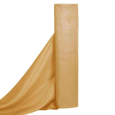 Golden fabric roll with flowing drape on a plain backdrop